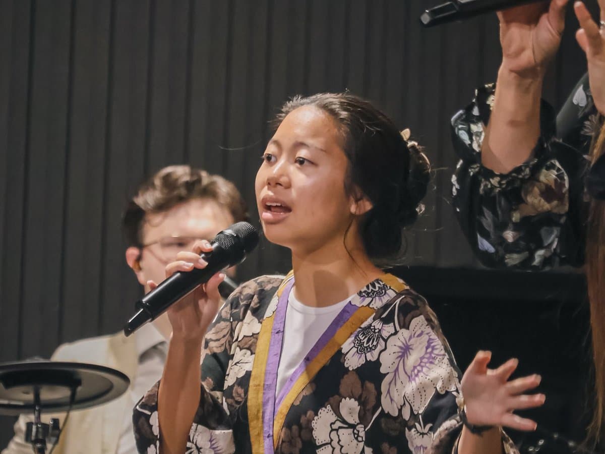 A young lady singing with the worship team.